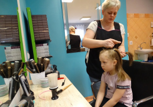 dziewczynka na krześle u fryzjera